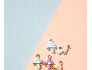 Macro shot of colorful enamel mushroom pendants with golden rings for DIY jewelry making