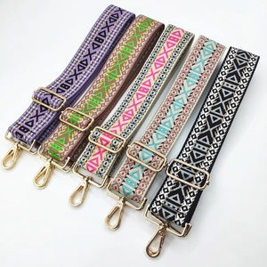 Close-up of five colorful ethnic style woven canvas bag straps with gold metal buckles
