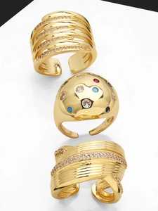 Detail of three gold adjustable rings featuring zircon accents and multi-color gemstones