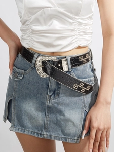 Detail of black crocodile pattern belt with silver rhinestone buckle and punk rivets