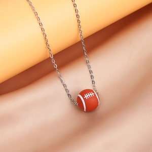 Detailed view of an orange rugby ball pendant on a silver stainless steel chain necklace
