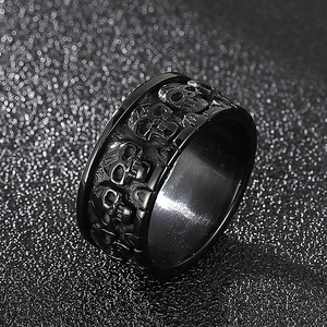 Detailed close-up of punk style black titanium ring with embossed skull relief patterns
