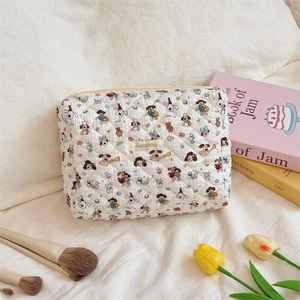Detailed view of a quilted makeup bag with cute cartoon dog prints and zipper closure