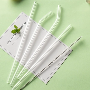 Set of 5 reusable colorful glass straws with cleaning brush on a minimalist green background