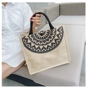 Close-up of geometric ethnic tote bag with jute texture and sturdy black woven handles
