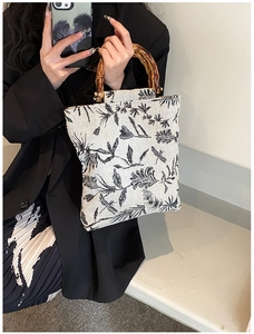 Detail of canvas handbag with bamboo handles and vintage botanical dragonfly print