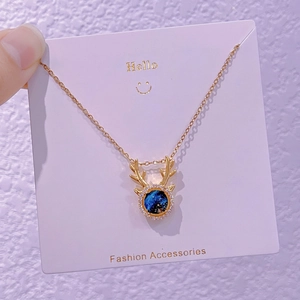 Dettaglio collana con corna di renna dorata, pietra galassia blu e cristalli