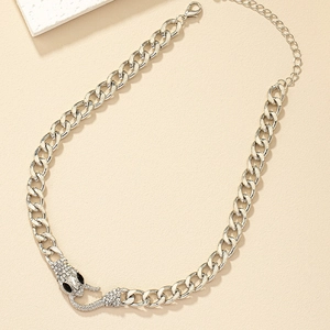 Macro shot of silver snake head pendant with white rhinestones and thick curb chain