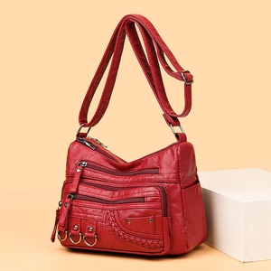 Fashionable red woven PU leather crossbody bag with multiple compartments on display