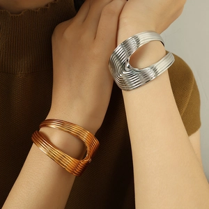 Minimalist 18K gold and silver textured sculptural metal cuffs for women shown on model