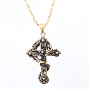 Detail of vintage gothic bronze cross pendant with coiled snake and skull on golden chain
