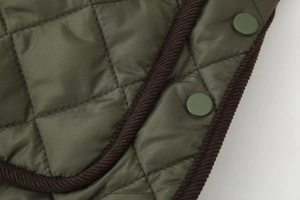 Détail de la veste matelassée en losanges avec bordure en velours côtelé marron