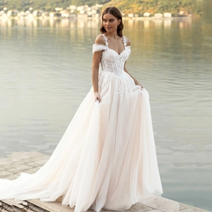 Detail of off-shoulder wedding dress with floral lace bodice and layered tulle skirt