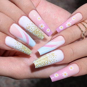 Detailed close-up of long trapezoid press-on nails with daisy and geometric patterns