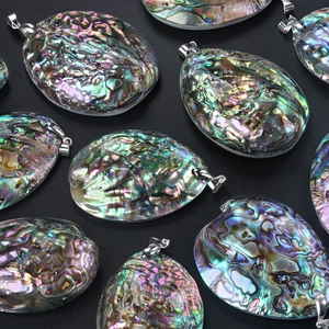 Natural colorful abalone shell pendants with silver metal bails on black background