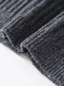 Close-up detail of dark grey ribbed knit fabric texture with soft wool-like finish