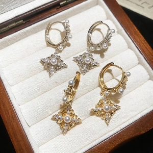 Gold and silver rhonbus pearl earrings with zircon inlay in a wooden jewelry box