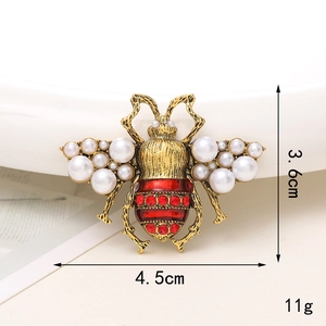 Dettaglio della spilla a ape con strass rossi e perle, dimensioni di 4,5cm per 3,6cm