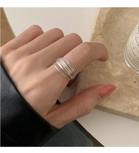 Detail shot of a minimalist multi-layer silver ring on finger with geometric overlapping lines