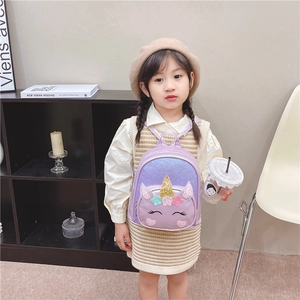 Toddler girl wearing a purple unicorn backpack with glitter horn and shiny sequins