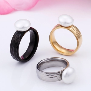Three-piece hammered stainless steel ring set with large white pearls in black, gold, and silver