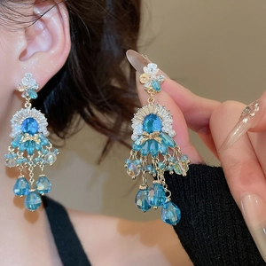 Dettaglio di orecchini floreali di lusso con cristalli blu ed eleganti nappe pendenti