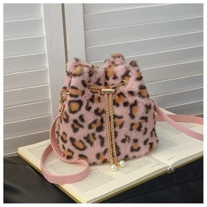 Detail of pink leopard plush bucket bag with golden chain and large pearl tassels