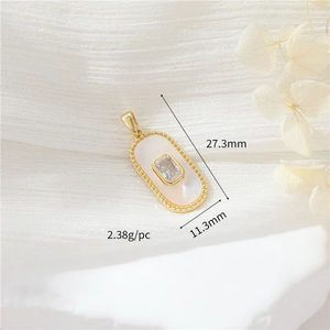 Detailed view of a gold oval pendant with white shell and zircon including measurements