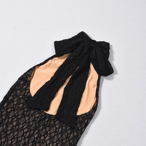 Détail de robe en dentelle noire avec grand nœud et doublure chair à texture fine
