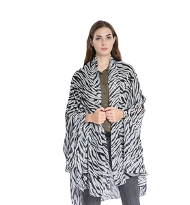 Detailed view of oversized zebra print scarf draped elegantly over a model's shoulder