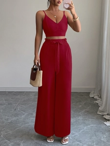 Elegante set rosso due pezzi con top a bretelle sottili e pantaloni larghi e fluidi