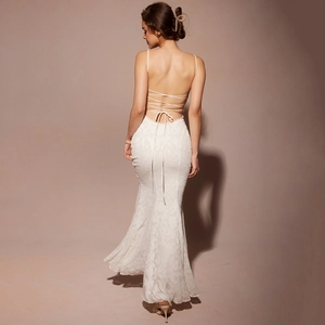 Détail de robe longue en dentelle blanche avec dos nu et fines bretelles croisées