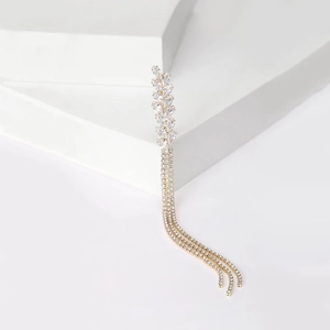 Close-up of golden wheat ear brooch with sparkling tassels and crystal rhinestones