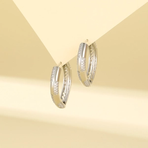 Silver geometric hoop earrings with checkered zircon inlay against soft background