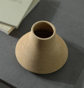 Detail of light brown ceramic vase showing delicate horizontal spiral texture and minimal design