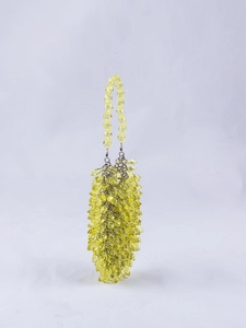 Macro detail of clear yellow beaded handbag with faceted crystal beads and metal rings