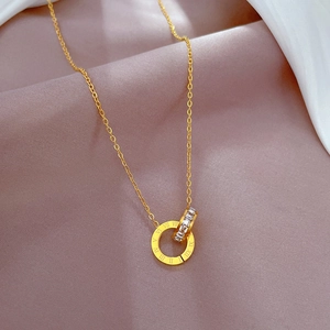 Macro detail of gold interlocking double rings featuring Roman numerals and crystal inlays