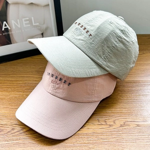 Detail of JOURNEY embroidery on warm solid color lamb wool baseball caps in soft pink and green