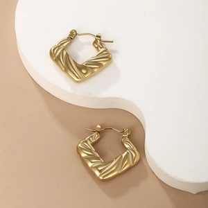 Detail view of gold-plated stainless steel hoop earrings with unique twisted texture