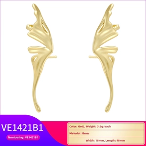 Macro detail of gold butterfly wing earrings with brass material and 48mm dimensions
