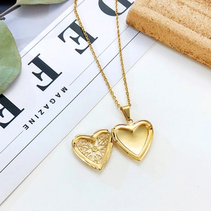 Close-up of golden heart locket necklace with intricate hollow pattern and open design