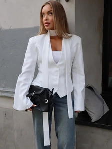 Women's white slim-fit blazer vest and blue straight jeans street style outfit