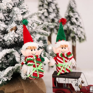 Weihnachtself-Plüschpuppen-Ornamente mit rot-grüner Kleidung in winterlicher Schneekulisse