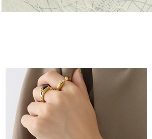 Close-up of a gold-plated flower ring set with a black gemstone on a model hand