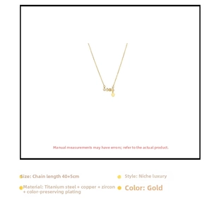 Detail of gold love necklace with zircon pendant and heart tassel on adjustable chain