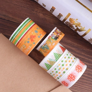 Set di 6 nastri washi natalizi con stampa in oro su un tavolo di legno rustico