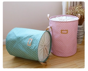 Detailed close-up of large canvas laundry baskets with drawstring closure and leather handles