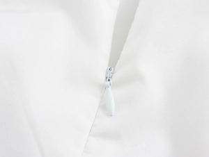 Close-up of invisible zipper and seam detailing on white embroidered vacation skirt set