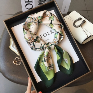 Detail of silk-feel tree of life scarf with floral butterfly print on luxury tray