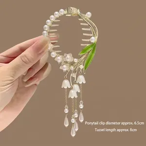 Détail de la pince à cheveux muguet avec pompons dorés et dimensions de 6,5 cm de diamètre